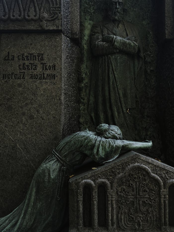 Moody image of a historic gravestone with intricate stone sculptures, capturing the essence of remembrance.